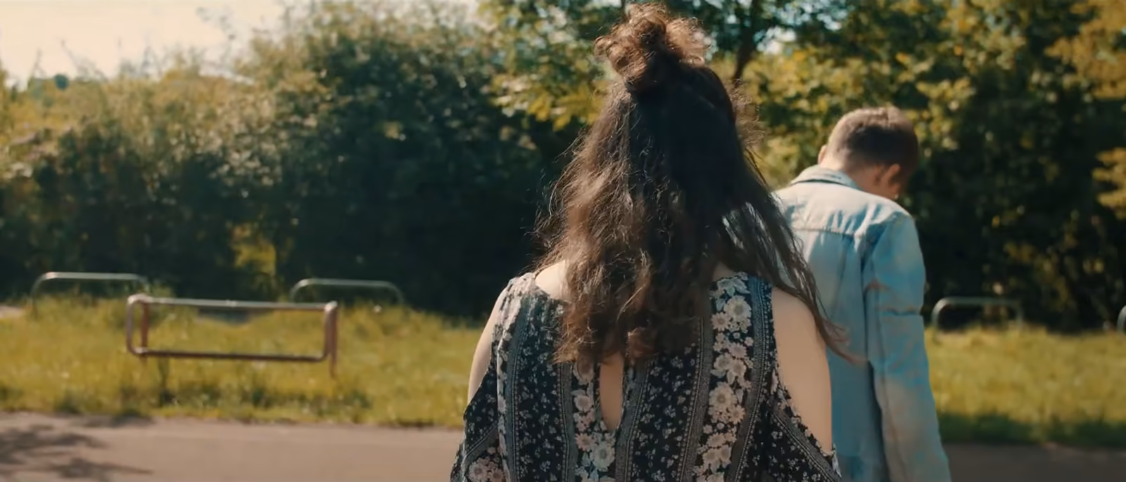 Dziewczyna idzie przez łąkę w ciepłym świetle, kadr z filmu ZOE